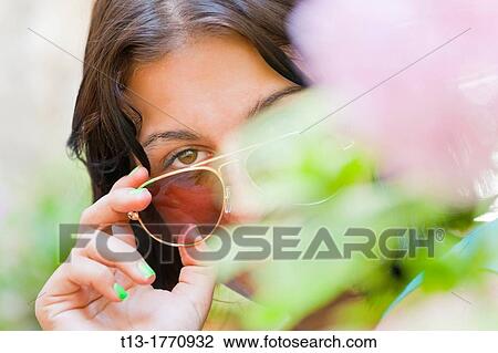 Girl is peeking through flowers View Large Photo Image Stock Image - Girl is peeking through flowers. Fotosearch