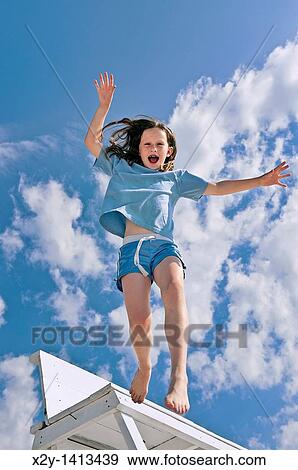 Girl jumping from a beach chair View Large Photo Image Stock Photo - Girl jumping from a beach chair. Fotosearch