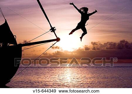 Girl jumping from yacht in sundown. Bora Bora. French Polynesia. View Large Photo Image Stock Photo - Girl jumping from yacht in sundown. Bora Bora. French Polynesia.. Fotosearch