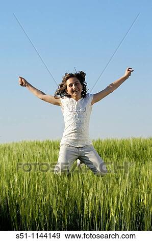 Stock Photo - girl jumping in field. Fotosearch