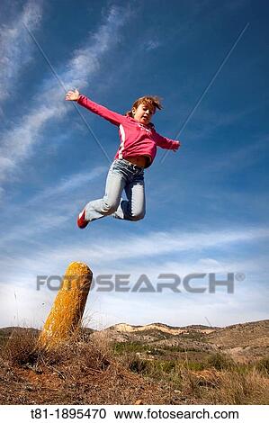 Girl jumping in the blue sky View Large Photo Image Stock Image - Girl jumping in the blue sky. Fotosearch