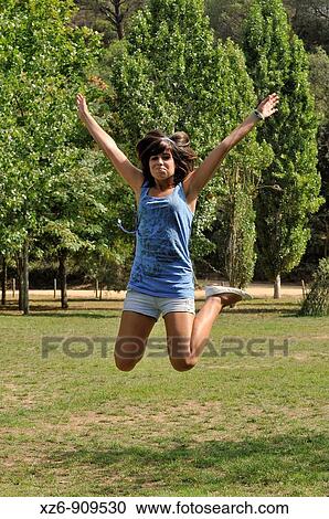 Stock Image - girl jumping in the park. Fotosearch