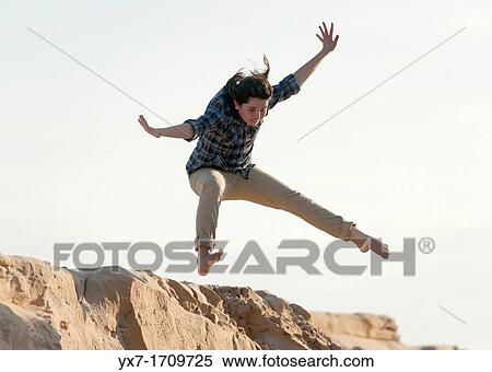 Stock Photography - Girl jumping on the beach. Tarifa, Costa de la Luz, Cadiz, Andalusia, Spain. Fotosearch