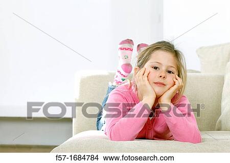Girl laying on coach View Large Photo Image Picture - Girl laying on coach. Fotosearch