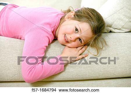 Girl laying on coach View Large Photo Image Picture - Girl laying on coach. Fotosearch
