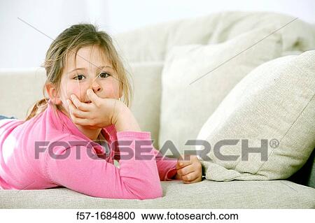 Stock Image - Girl laying on coach. Fotosearch