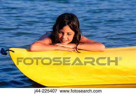 Stock Photo - Girl leaning on kayak boat in a lake. Fotosearch