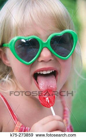 Girl licking lollipop View Large Photo Image Stock Photo - Girl licking lollipop. Fotosearch