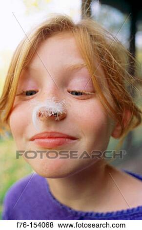 Girl looking at feather on her nose View Large Photo Image Stock Photo - Girl looking at feather on her nose. Fotosearch