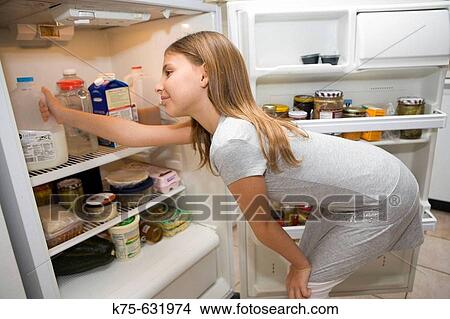Girl looking in refrigerator View Large Photo Image Picture - Girl looking in refrigerator. Fotosearch