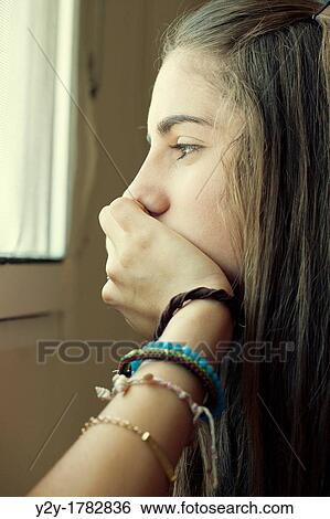 Girl looking through the window View Large Photo Image Stock Photograph - Girl looking through the window. Fotosearch