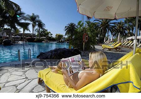 Girl lying by the pool reading. View Large Photo Image Stock Photograph - Girl lying by the pool reading.. Fotosearch