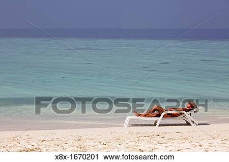 Girl lying on the beach at the seashore, Biyadhoo island, Maldives View Large Photo Image Stock Image - Girl lying on the beach at the seashore, Biyadhoo island, Maldives. Fotosearch