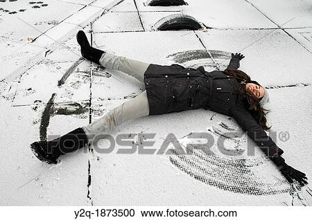 Stock Image - Girl making a snow angel. Fotosearch