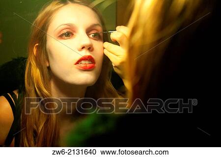 Stock Image - Girl making herself up. Fotosearch