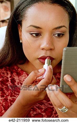 Girl making up her lips View Large Photo Image Stock Photo - Girl making up her lips. Fotosearch