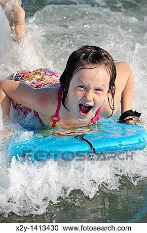 Girl on a wave board enjoying the ride, Ocean City, New Jersey, USA View Large Photo Image Stock Image - Girl on a wave board enjoying the ride, Ocean City, New Jersey, USA. Fotosearch
