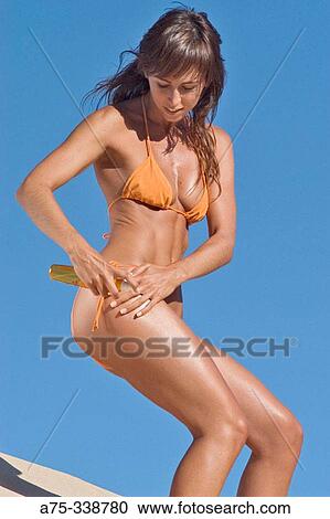 Girl on the beach putting on cream View Large Photo Image Stock Image - Girl on the beach putting on cream. Fotosearch