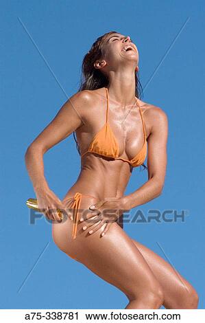 Girl on the beach putting on cream View Large Photo Image Stock Image - Girl on the beach putting on cream. Fotosearch