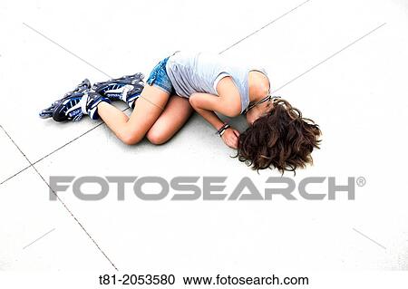Stock Image - Girl on the floor by skating fall. Fotosearch