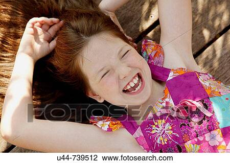 Stock Image - Girl on the flor having fun and laugh. Fotosearch