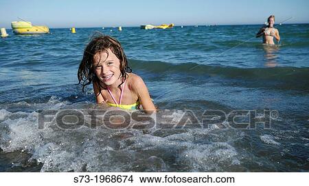 Picture - Girl playing in the beach. Fotosearch