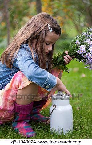 Girl playing in the garden with recently picket bouquet of asters and vintage milk can. Slovenian countryside. View Large Photo Image Picture - Girl playing in the garden with recently picket bouquet of asters and vintage milk can. Slovenian countryside.. Fotosearch
