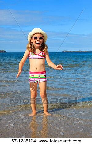 Picture - girl playing on sandy beach, Sutherland, Scotland. Fotosearch