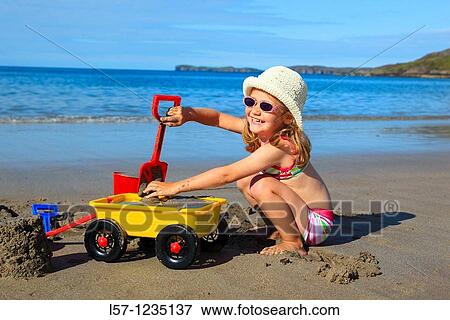 Stock Photo - girl playing on sandy beach, Sutherland, Scotland. Fotosearch