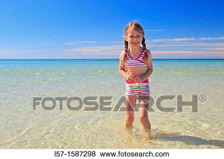 Stock Photo - girl playing on sandy beach, Sutherland, Scotland. Fotosearch