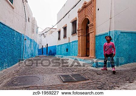 Girl playing on the blue streets of Kasbah of the Oudayas, Rabat, Morocco. View Large Photo Image Stock Photo - Girl playing on the blue streets of Kasbah of the Oudayas, Rabat, Morocco.. Fotosearch