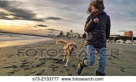 Stock Photo - Girl playing with dog in the beach, Pedregalejo beach, MBlaga, Andaluc? a, Spain. Fotosearch