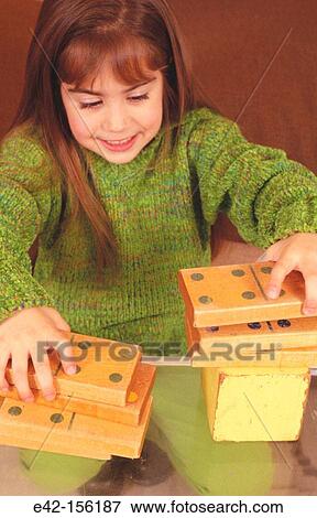 Girl playing with dominoes View Large Photo Image Stock Photo - Girl playing with dominoes. Fotosearch