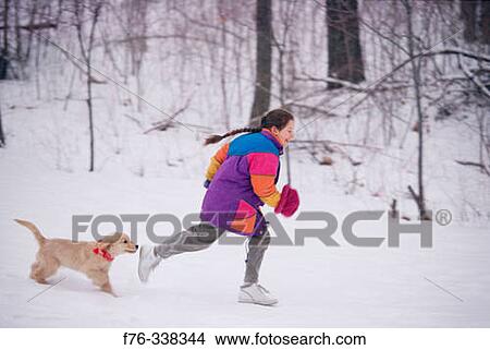 Girl playing with puppy in snow View Large Photo Image Picture - Girl playing with puppy in snow. Fotosearch