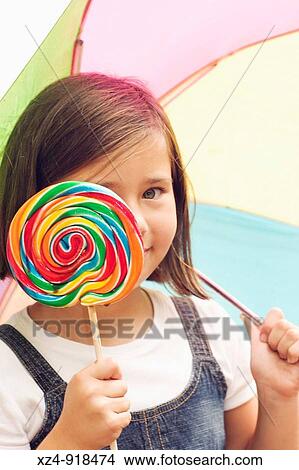girl plays peek-a-boo with lollipop in the rain View Large Photo Image Picture - girl plays peek-a-boo with lollipop in the rain. Fotosearch