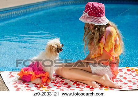 Girl plays with her white puppy dog on polka dot towel near swimming pool. View Large Photo Image Stock Image - Girl plays with her white puppy dog on polka dot towel near swimming pool.. Fotosearch