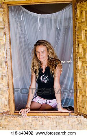 Stock Image - girl posing on plaited bamboo window. Fotosearch
