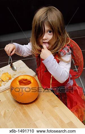 Stock Image - Girl preparing jack o? lantern. Fotosearch