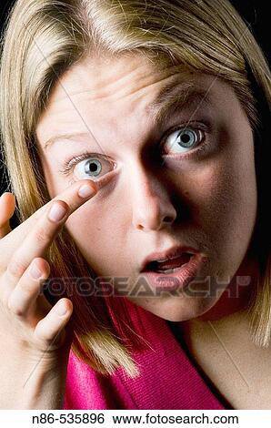 Stock Photograph - Girl putting in contact. Fotosearch