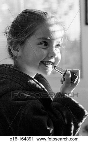 Stock Image - Girl putting on lipstick. Fotosearch