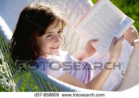 Girl reading a book on a hammock View Large Photo Image Stock Photo - Girl reading a book on a hammock. Fotosearch