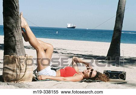 Stock Photography - girl relaxed on the beach talking. Fotosearch