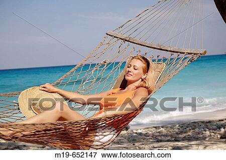 Girl relaxing in a beach hammock View Large Photo Image Stock Photo - Girl relaxing in a beach hammock. Fotosearch