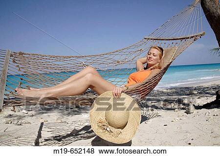 Girl relaxing in a beach hammock View Large Photo Image Stock Photo - Girl relaxing in a beach hammock. Fotosearch