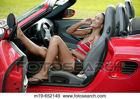 Girl relaxing in a covertible on a cell phone View Large Photo Image Stock Photo - Girl relaxing in a covertible on a cell phone. Fotosearch