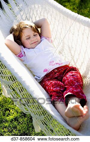 Girl resting on a hammock outdoors View Large Photo Image Picture - Girl resting on a hammock outdoors. Fotosearch
