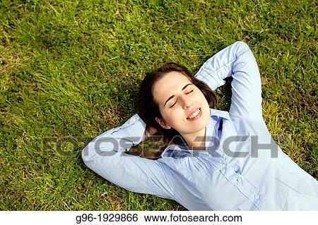 Girl resting on the grass View Large Photo Image Stock Photograph - Girl resting on the grass. Fotosearch