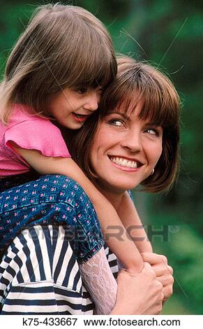 Girl riding piggyback on mom's shoulders View Large Photo Image Stock Photo - Girl riding piggyback on mom's shoulders. Fotosearch