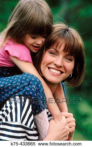 Girl riding piggyback on mom's shoulders View Large Photo Image Stock Photography - Girl riding piggyback on mom's shoulders. Fotosearch