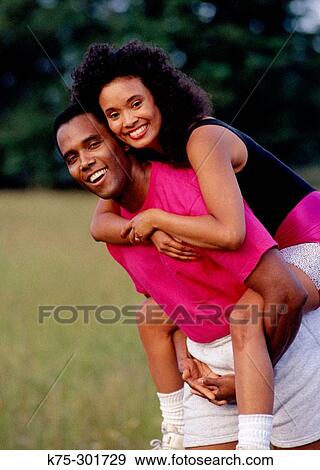Girl riding piggyback View Large Photo Image Stock Photo - Girl riding piggyback. Fotosearch